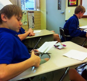 Eighth grader Barry Redding cuts a luminaria for use in "Pack Time."