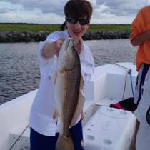 Charlie holding up a fish that he caught after going fishing with family