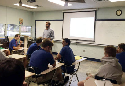 Roger Bacon, the new religion IV teacher, talking to students about their reflection assignment. (Photo by Ethan Hopel)